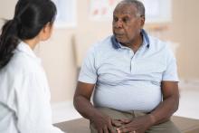 A senior male of African descent speaks to his doctor about some recent pain he has experienced